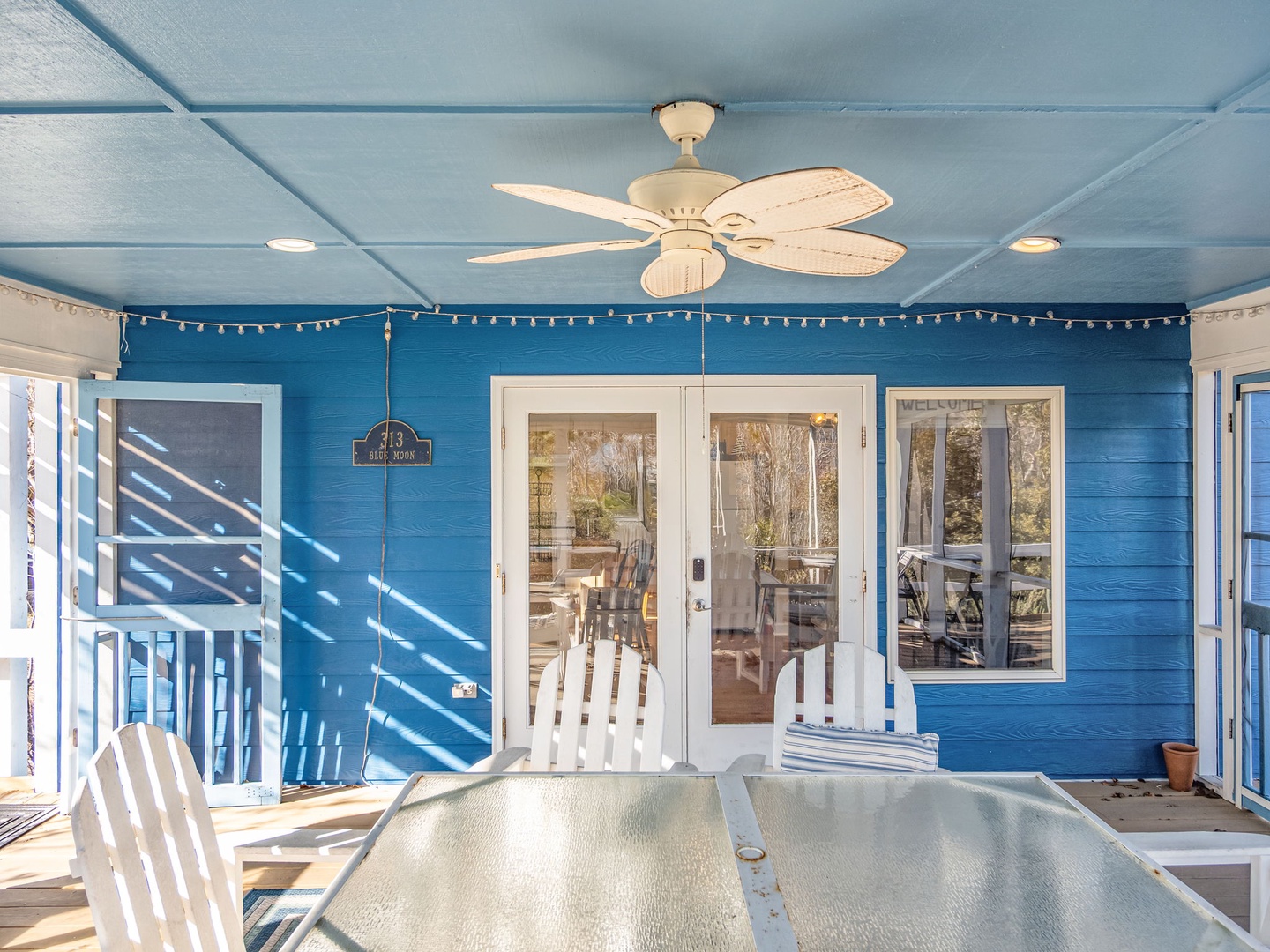 Your covered porch offers the perfect spot to unwind with coastal breezes and sparkling sunlight filtering through white railings.