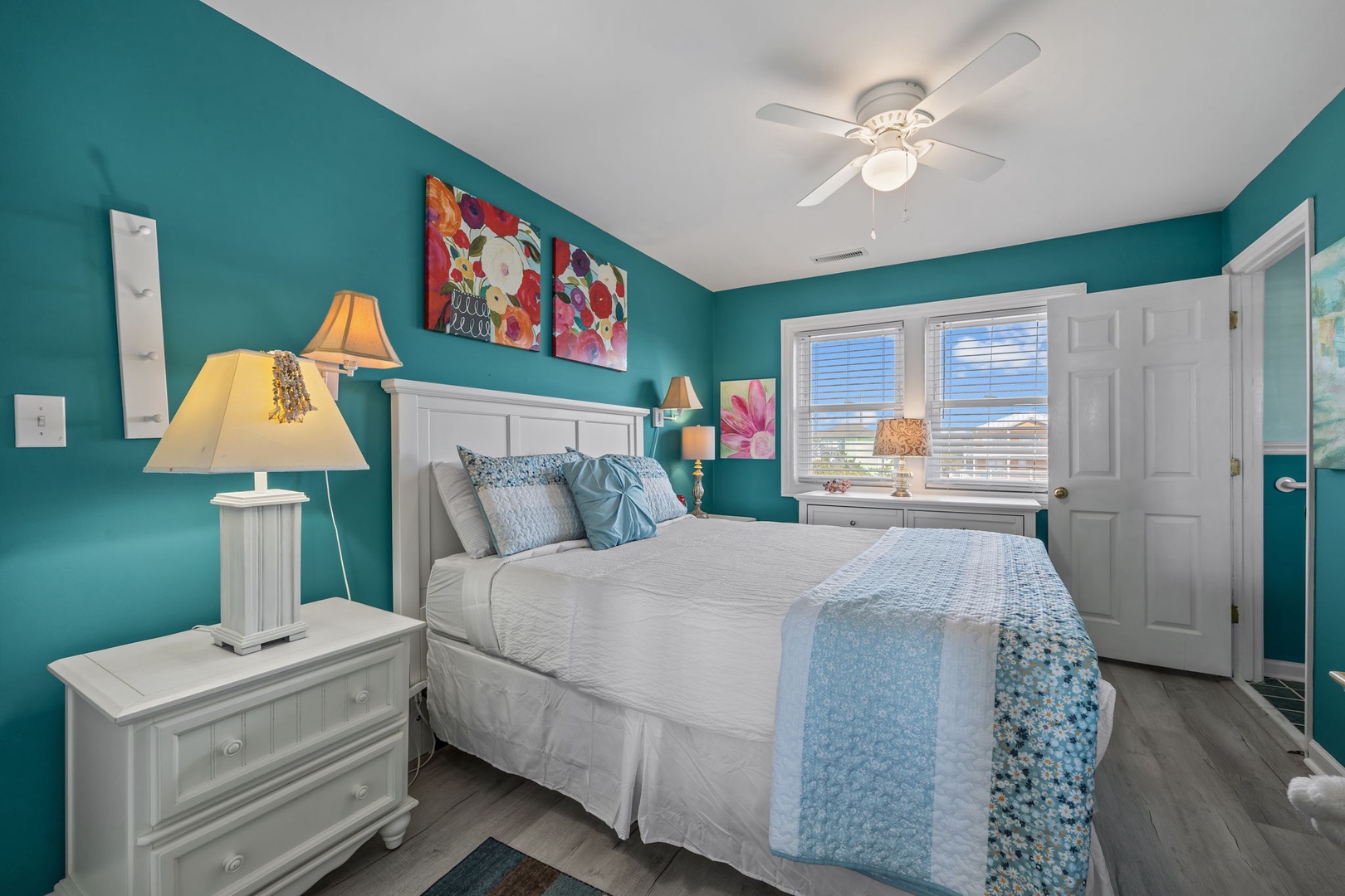 Unwind in your vibrant teal bedroom where soft blue linens and warm lamps create a peaceful retreat.
