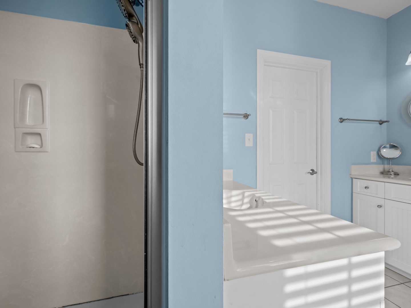 Your private bathroom features soothing blue walls, a spacious soaking tub, and a refreshing shower—perfect for unwinding after exploring.