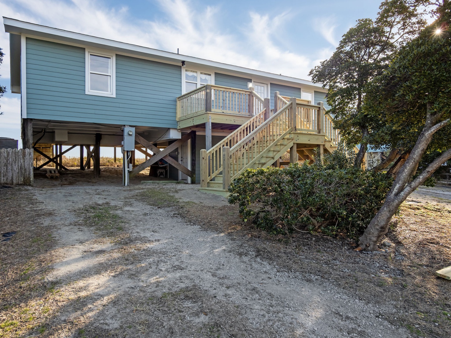 Charming, elevated beach house surrounded by trees in a peaceful setting.