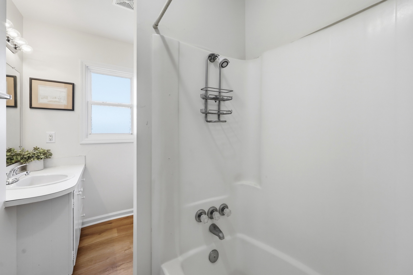 Spotless bathroom with a bright tub-shower combo, modern fixtures, and a clean white vanity that offers plenty of counter space for your essentials.