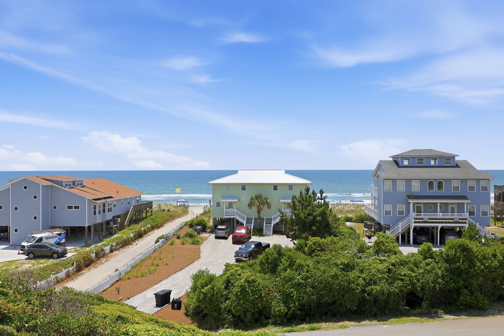 Beachfront vacation homes offer direct access to sandy shores and ocean views, surrounded by coastal greenery and just steps from the water's edge.