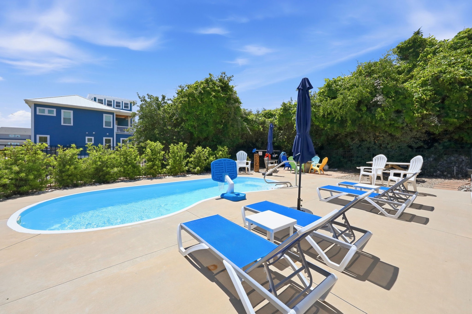 Your private pool awaits, surrounded by lounge chairs and shaded seating. Soak up the sun, take a refreshing dip, and unwind in this inviting outdoor oasis framed by lush greenery.