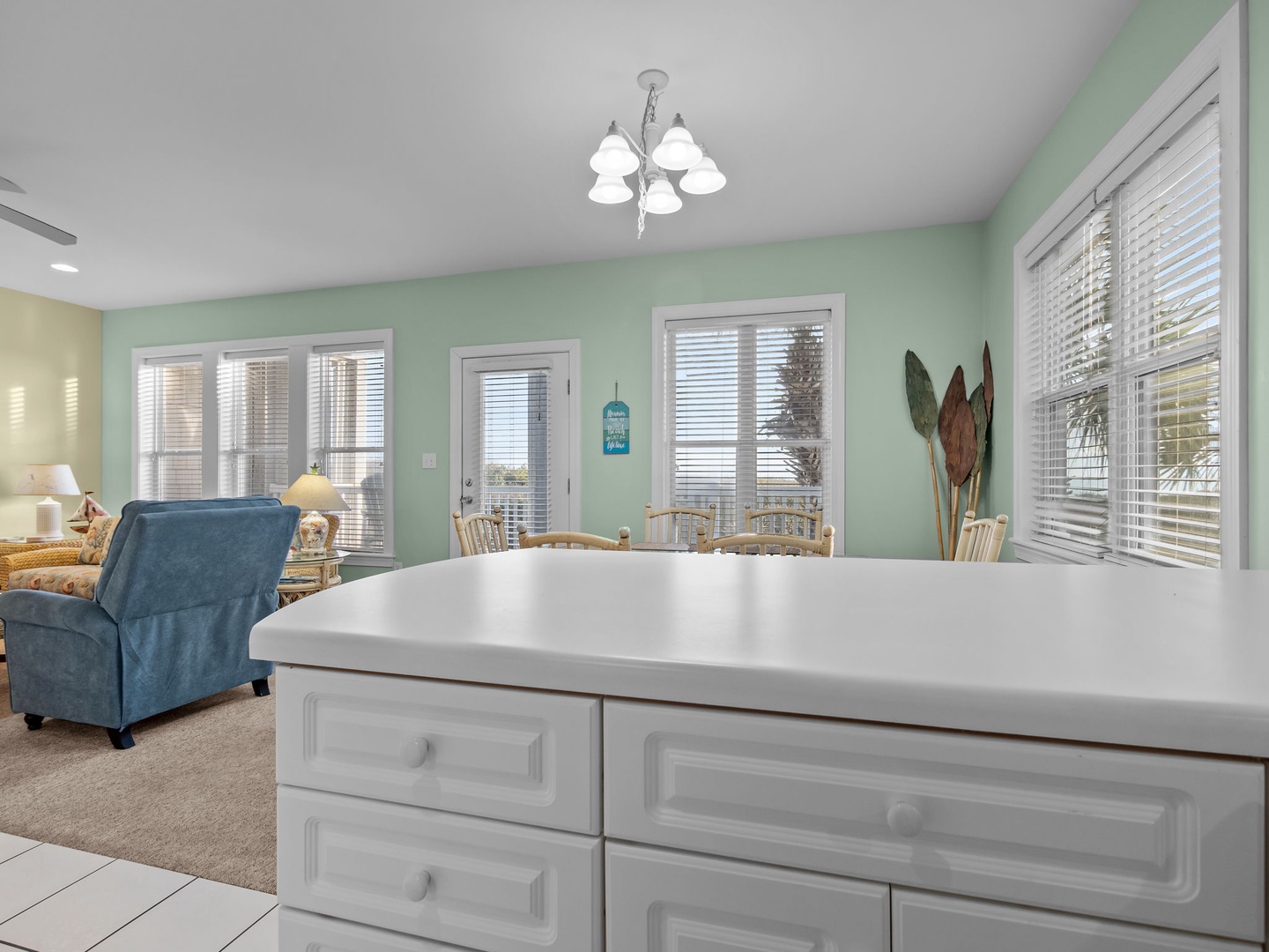 Gather around your bright dining area, where soft green walls and natural light create the perfect setting for morning coffee or evening meals.