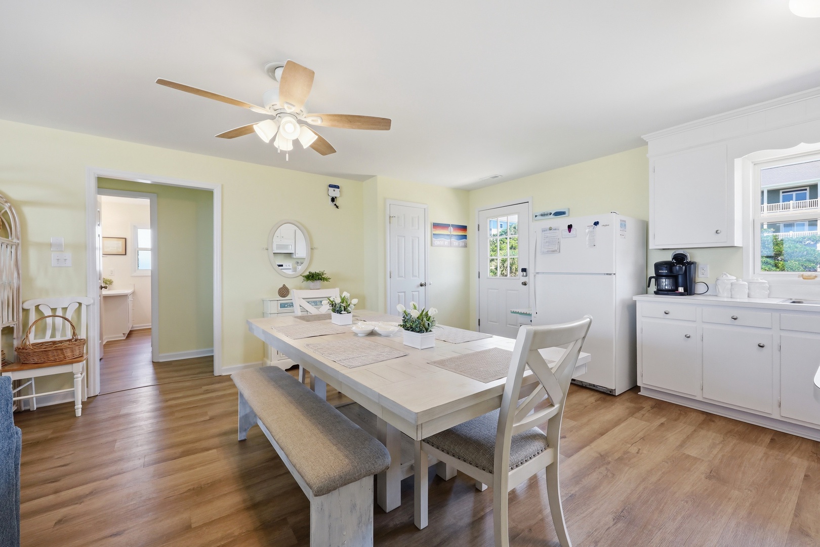 Gather around the welcoming dining table where morning coffee and home-cooked meals become cherished memories. Soft yellow walls and coastal touches create a cheerful, relaxed atmosphere for your group.