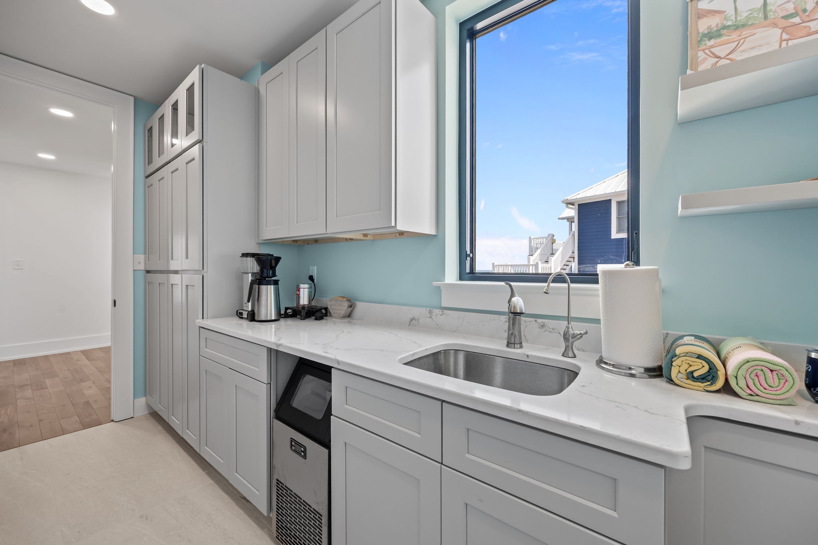 Your modern kitchen features marble countertops, stainless appliances, and coastal views through large windows.