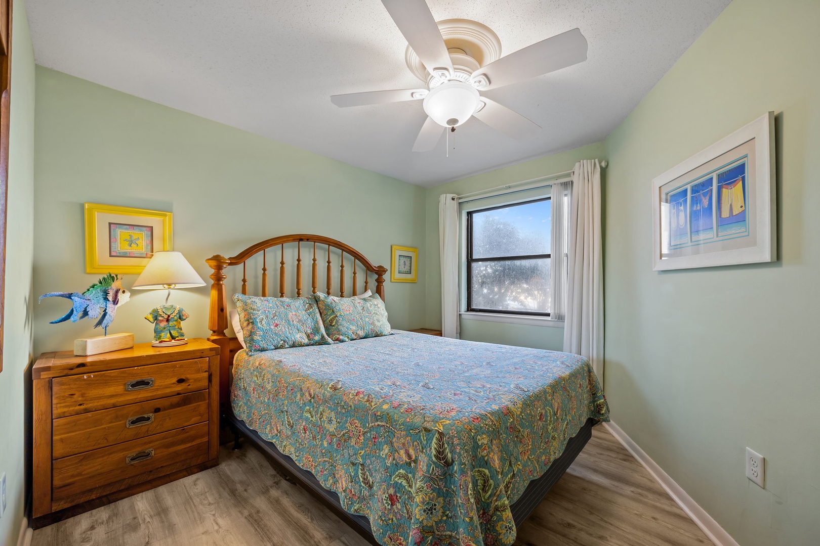 Your peaceful bedroom features a comfortable bed with charming coastal-inspired linens and soothing sage walls that invite restful sleep.