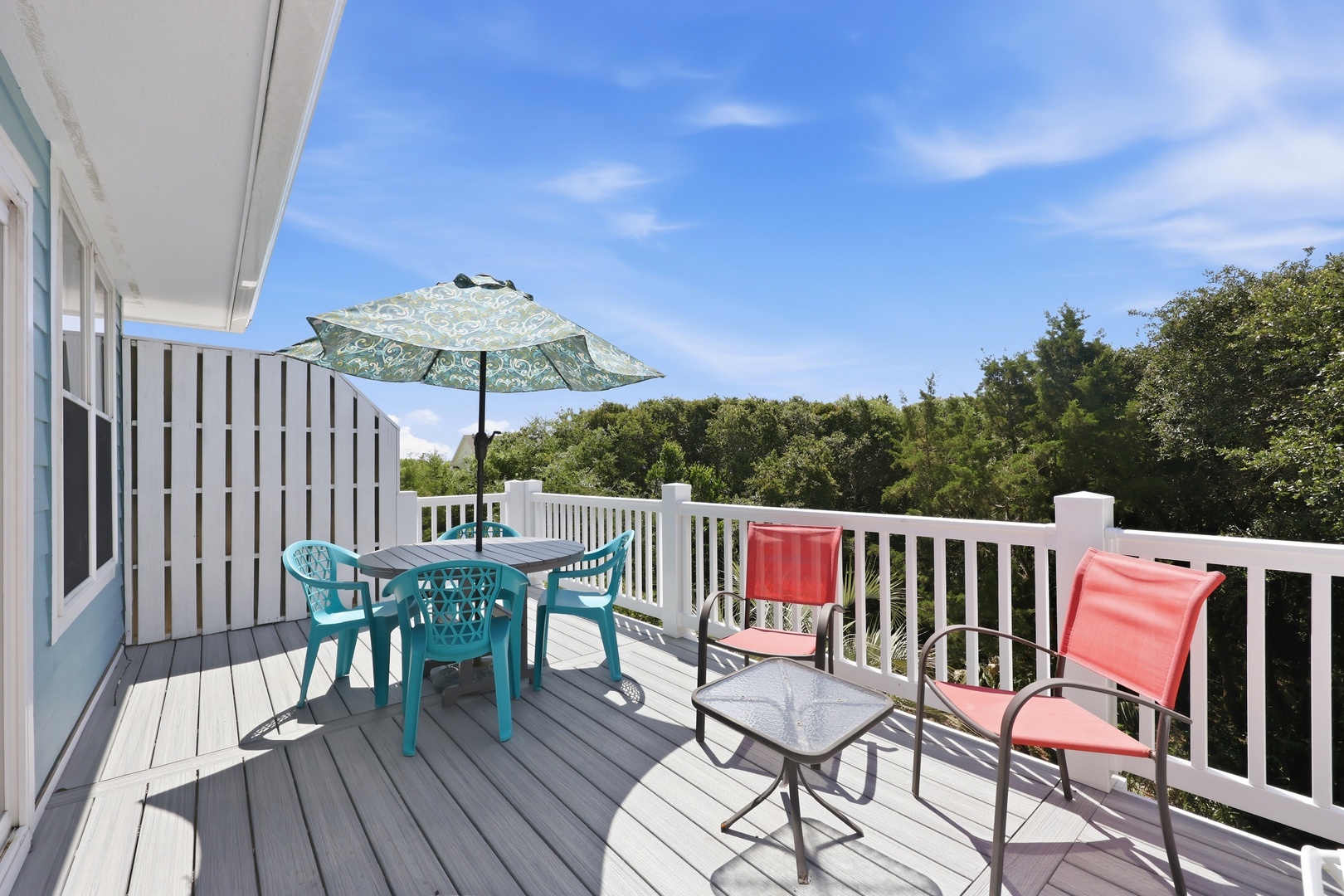 Expansive deck offering serene views of natural surroundings, with outdoor dining and lounge areas perfect for morning coffee or sunset gatherings.