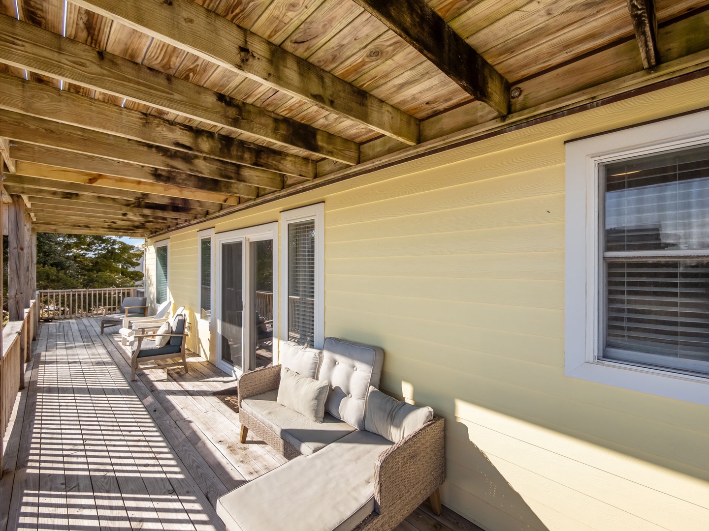 Your private covered balcony invites relaxation with comfortable seating and scenic views beyond the treetops.