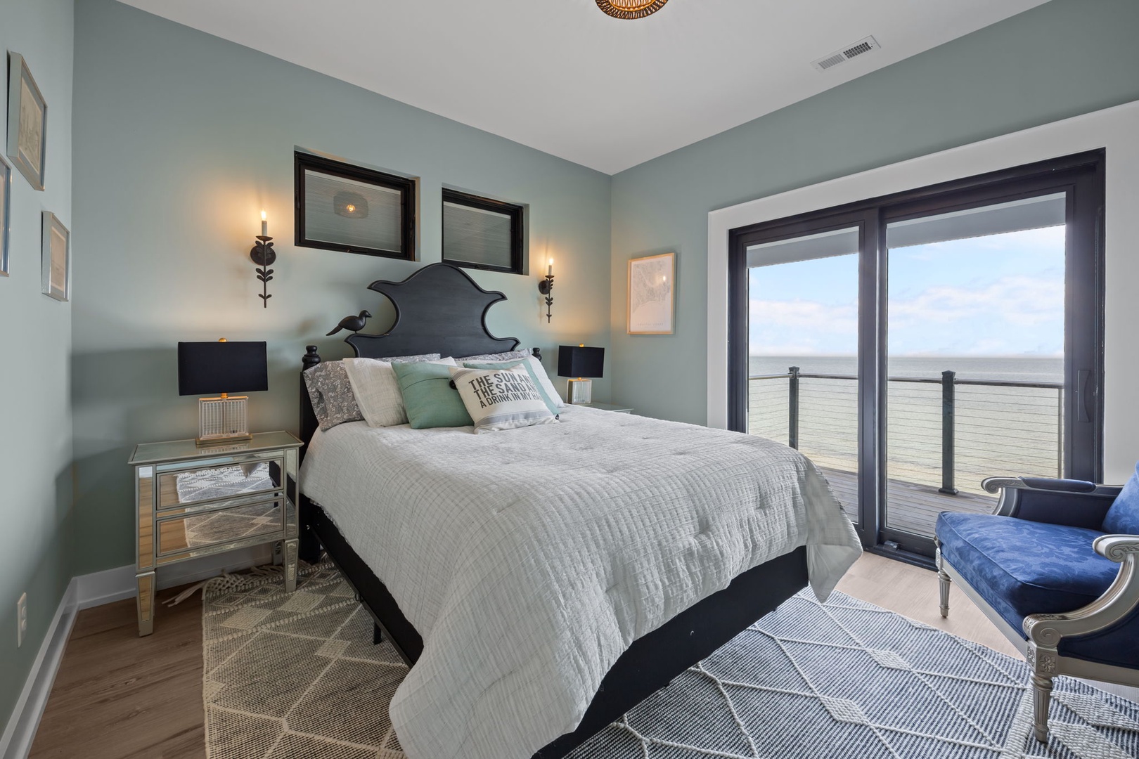 Wake up to endless ocean views from your private balcony in this serene coastal bedroom retreat.