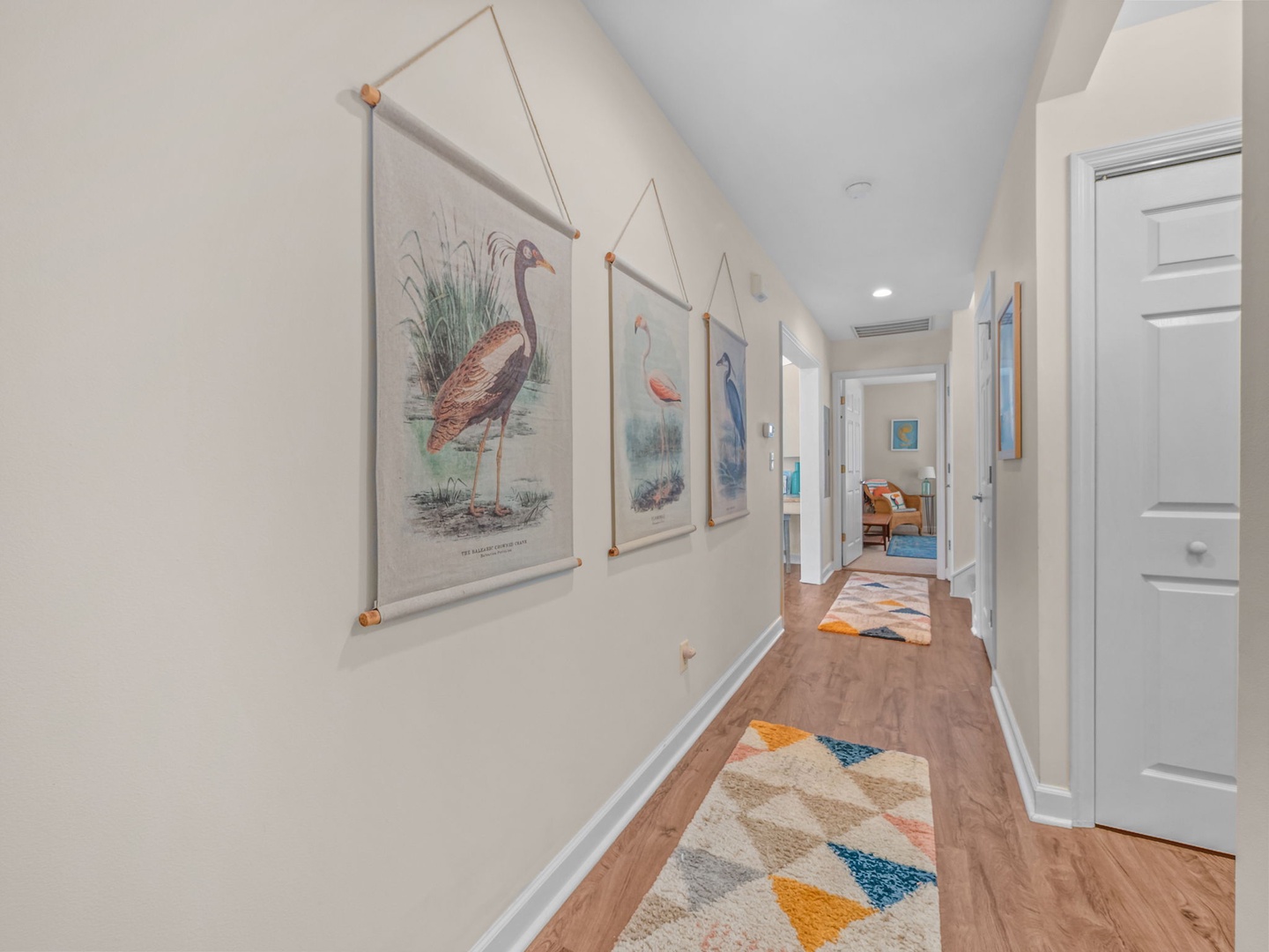 Bright hallway adorned with charming bird prints guides you between your comfortable living spaces.