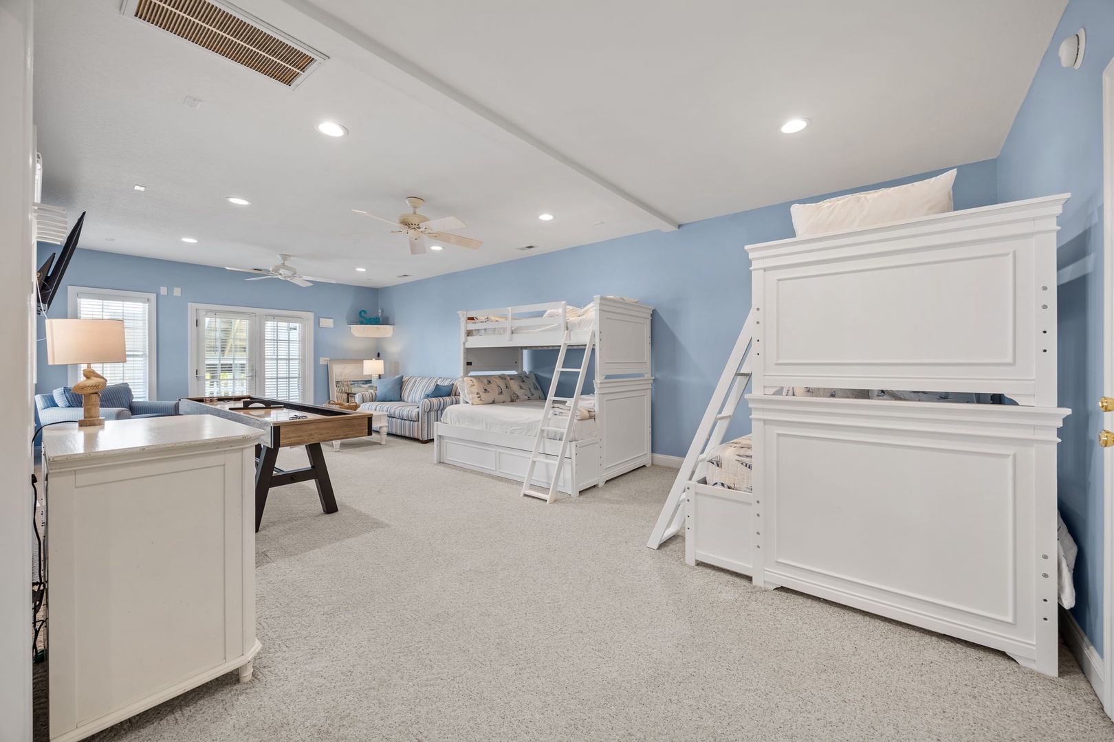 Your family's coastal retreat features bunk beds for the kids, with soft blue walls and ample space for everyone to unwind together.