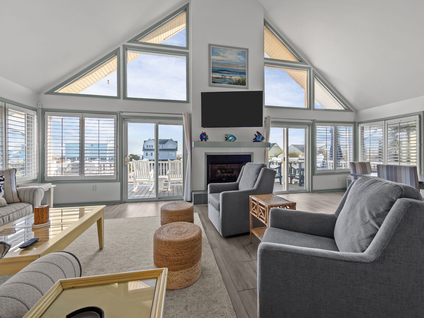 Relax in your bright living room with soaring ceilings, cozy fireplace, and stunning ocean views through floor-to-ceiling windows.