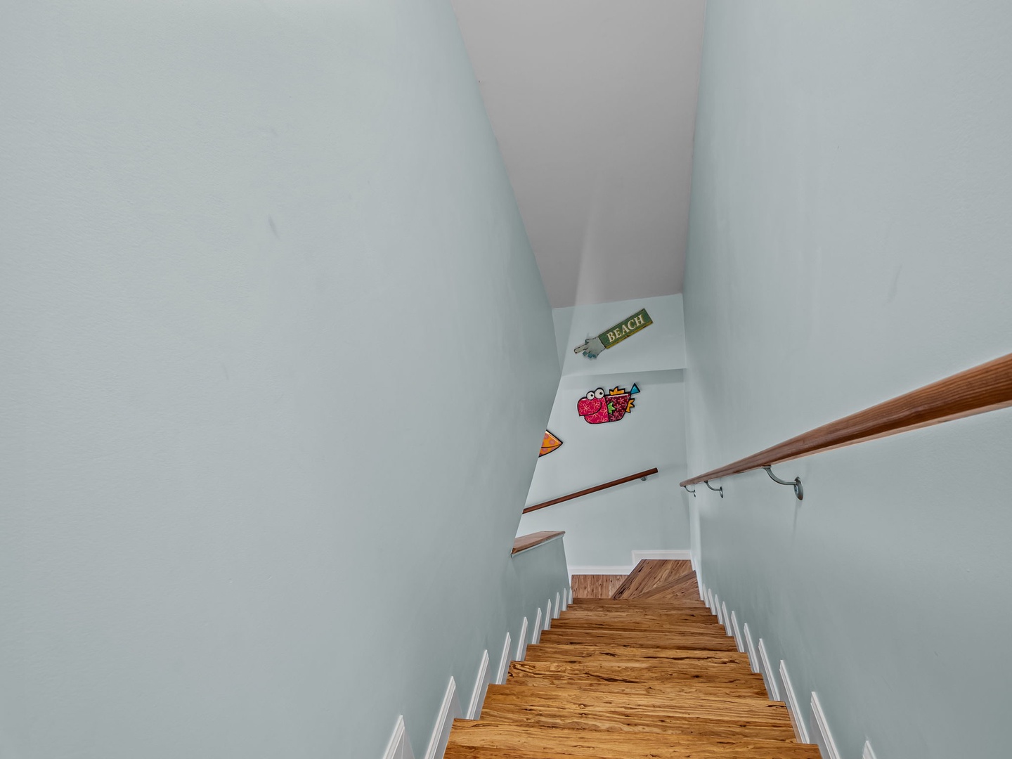 Climb these welcoming wooden stairs to discover your upstairs retreat, where charming vintage posters add personality to the bright walls.