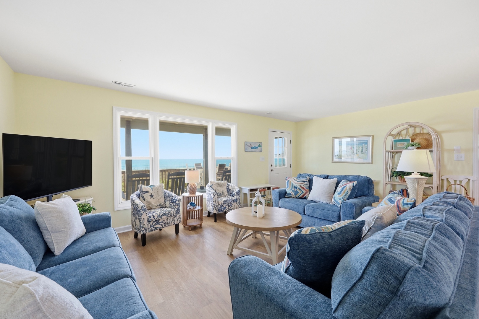 Your coastal escape awaits—imagine relaxing on plush sofas as ocean breezes drift through expansive windows, framing stunning sea views and inviting you to unwind completely.