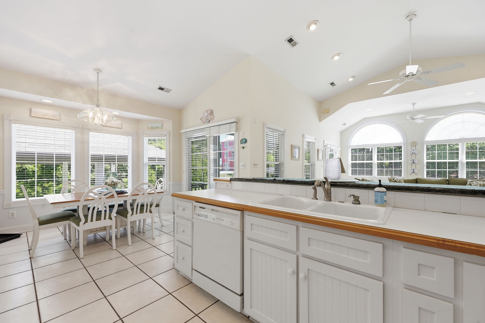 Step into your bright, airy kitchen and dining space where natural light pours through generous windows. White cabinetry and warm countertops create a welcoming spot to cook and gather.