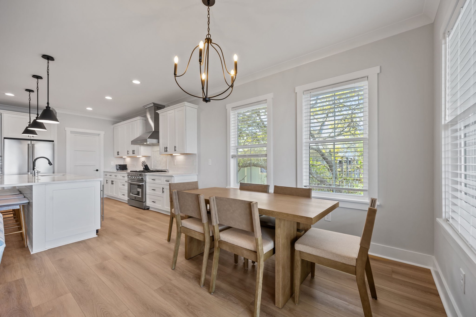You'll love gathering around this elegant dining table in your bright, modern kitchen with premium appliances and charming chandelier overhead.