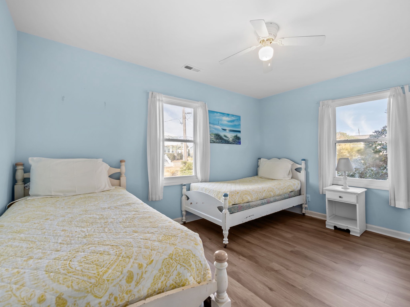 Unwind in this twin bedroom with natural light streaming through windows.