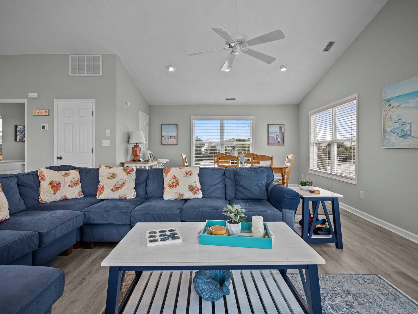 Sink into this plush navy sectional while ocean breezes flow through your bright living space, where coastal artwork and warm touches create your perfect beach getaway.