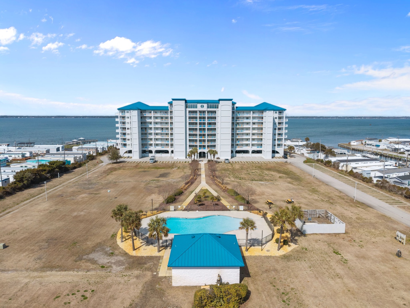 Oceanfront resort building featuring outdoor pools and direct beach access in a coastal community setting.