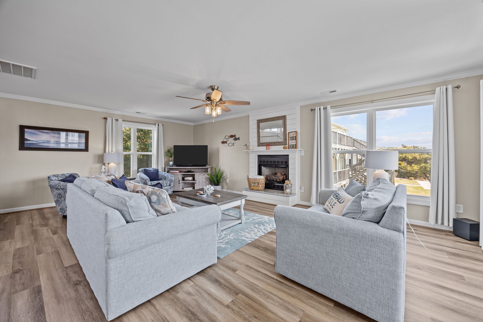 Unwind in your spacious living room featuring plush seating, warm fireplace, and panoramic windows showcasing stunning coastal views.