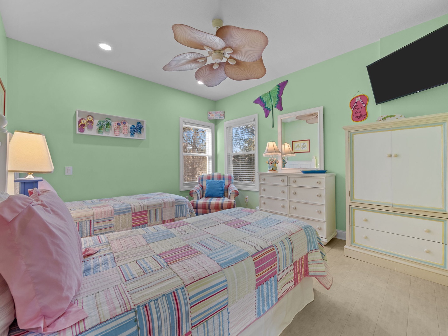 Your peaceful bedroom features comfortable bedding, tropical ceiling fan, and sunny windows for natural light and relaxing views.