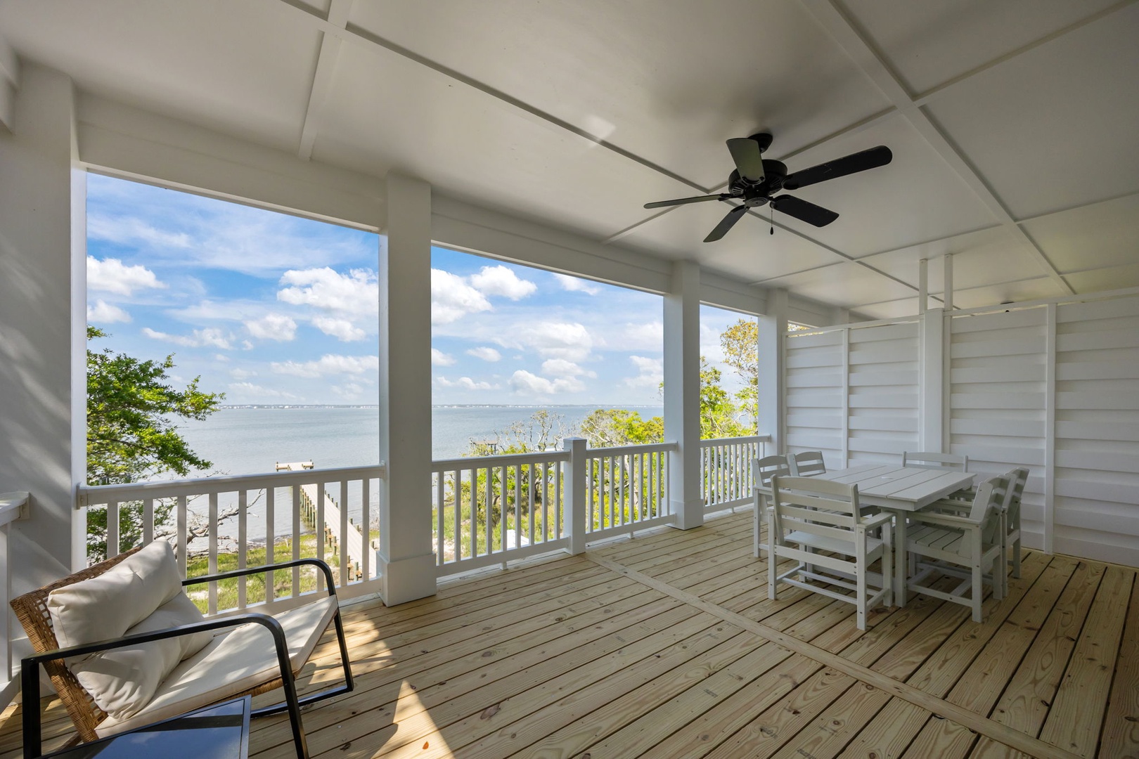Sip your morning coffee while soaking in stunning water views from this peaceful screened porch with comfortable seating.