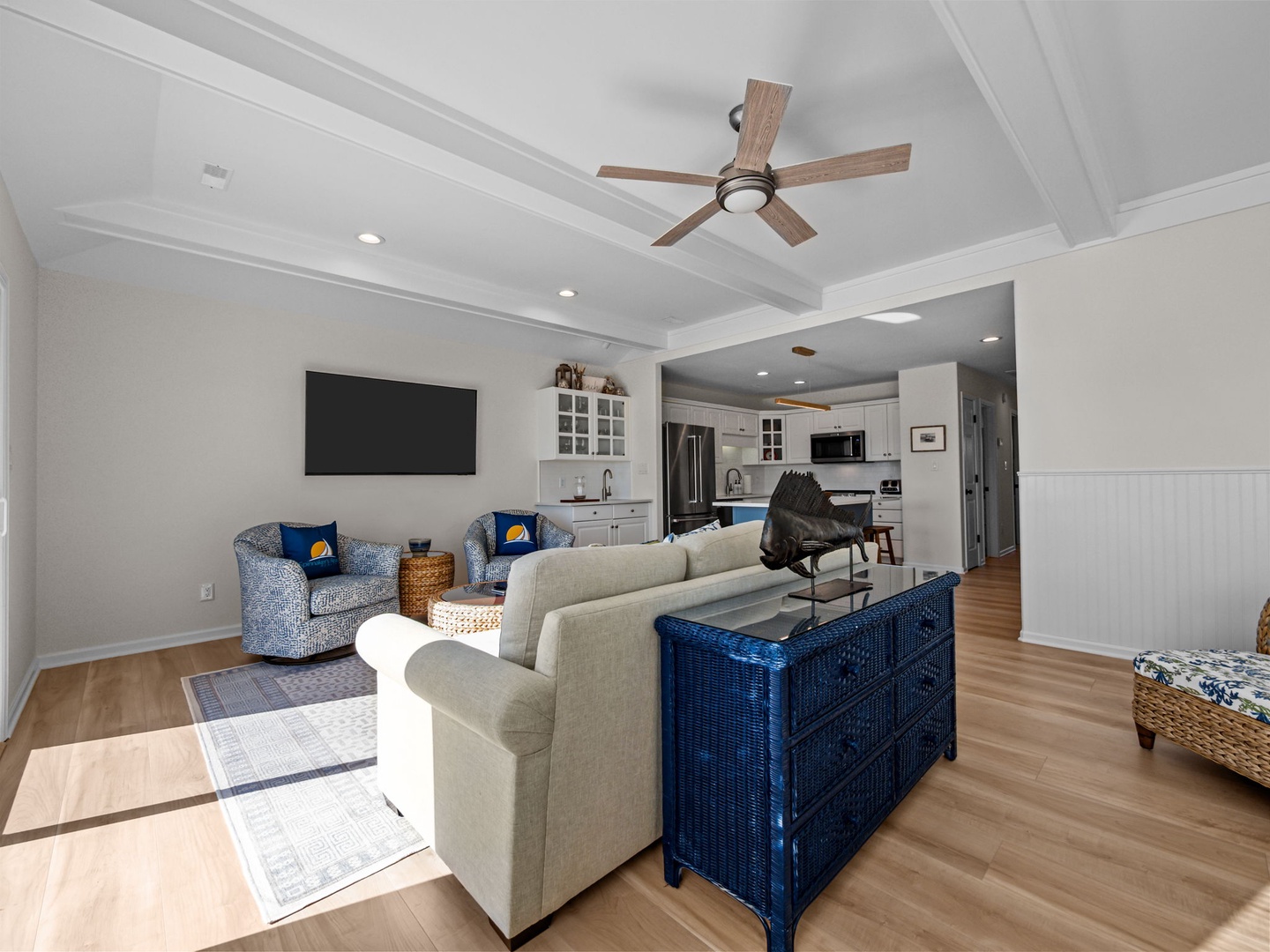 Relax in your beautifully appointed living room with soaring coffered ceilings, coastal-inspired furnishings, and an open flow to your fully equipped kitchen.