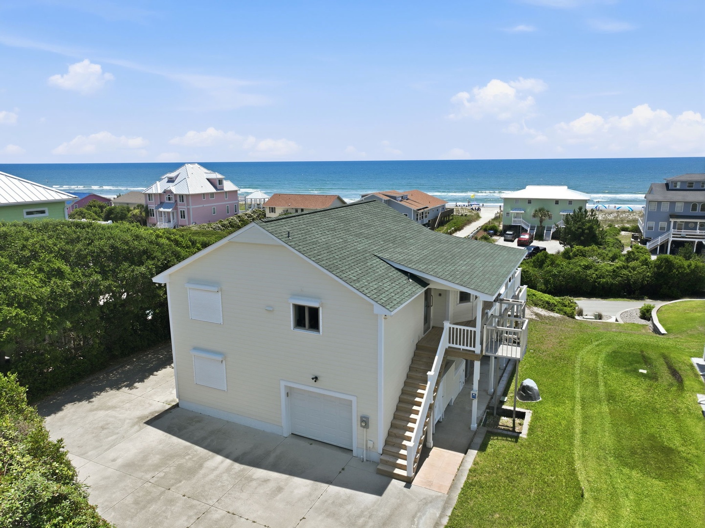 Coastal beach home nestled in a quiet residential neighborhood, just a short stroll from the ocean. Multiple levels of outdoor decking and proximity to sandy shores.