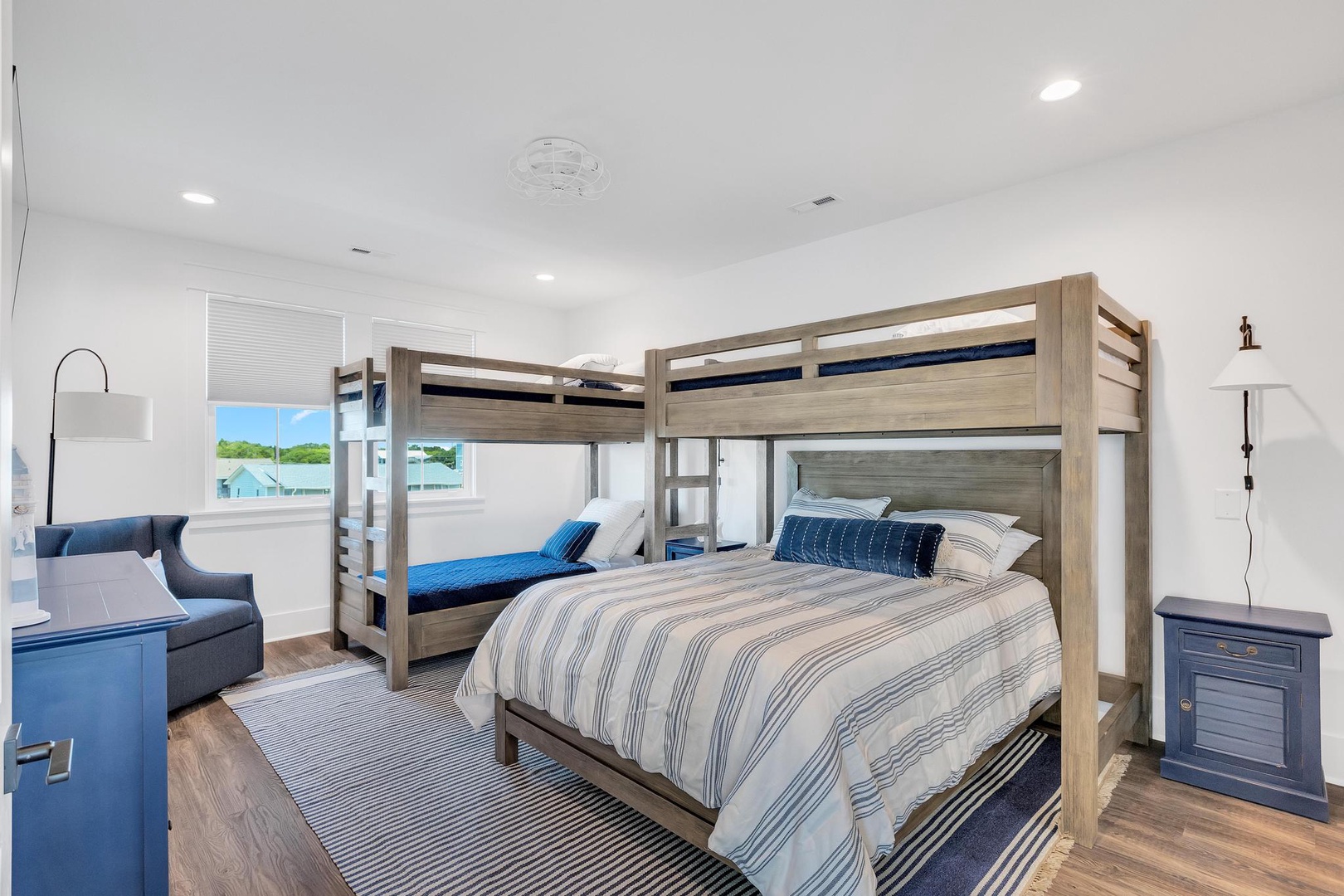 Gather the whole crew in this coastal-inspired bedroom, where two sturdy bunk beds with nautical-striped bedding create cozy sleeping nooks for everyone.