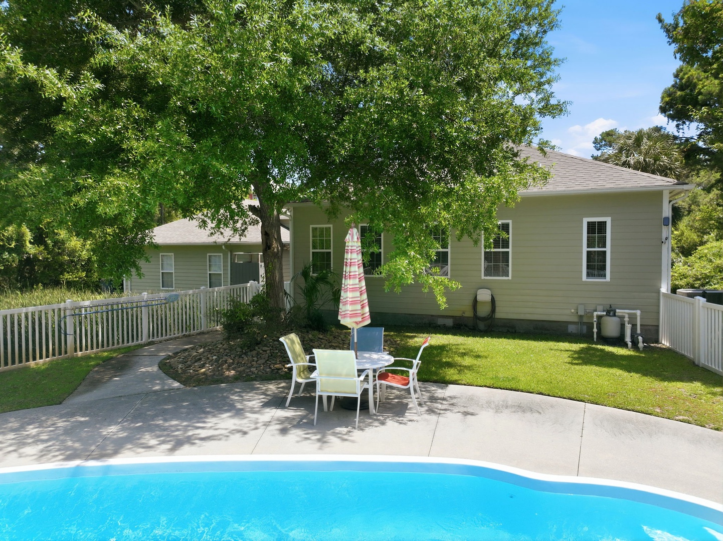 Enjoy sunny afternoons by your private pool, with plenty of patio seating under the shade of a mature tree and a spacious, fenced backyard for ultimate relaxation.
