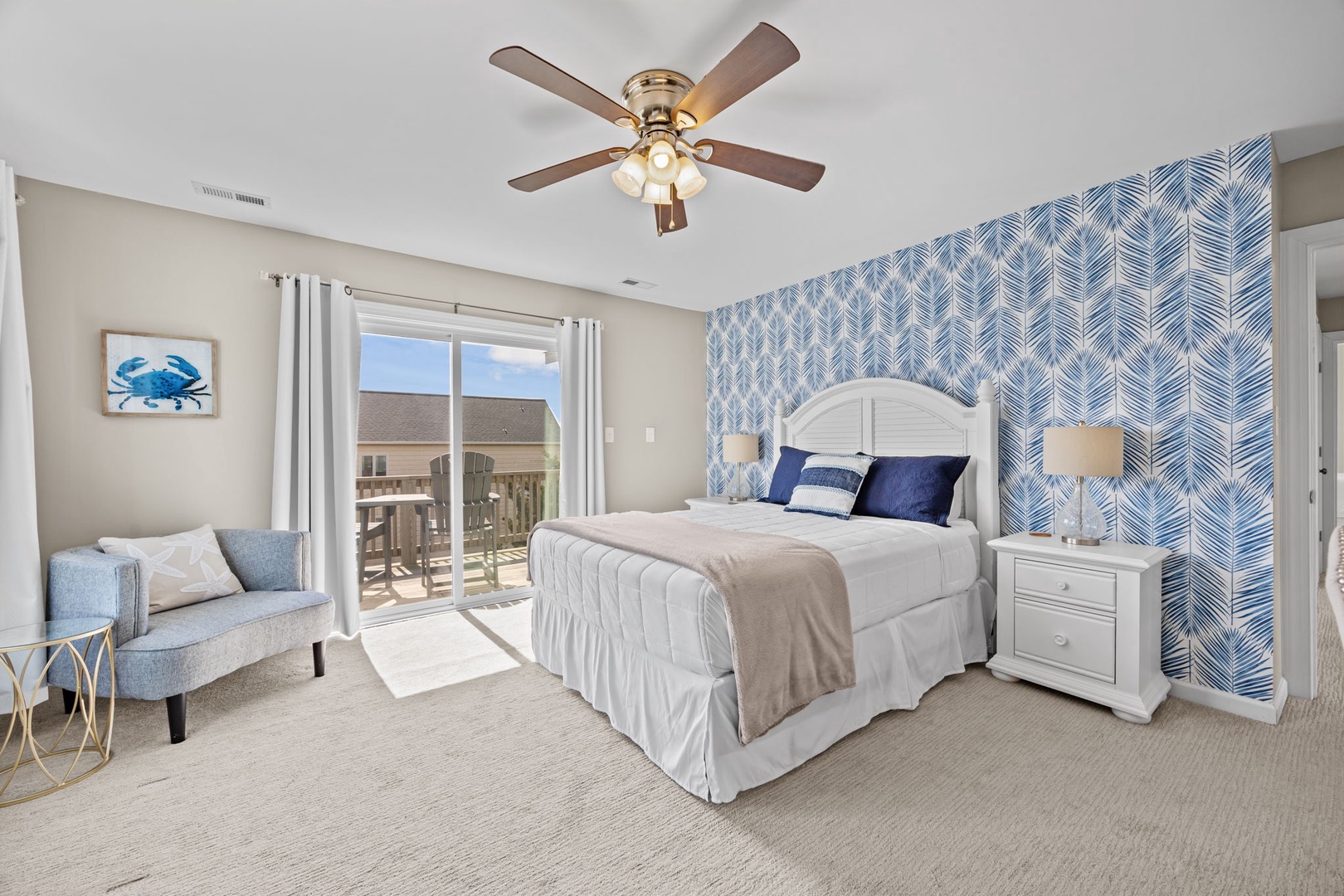 Your coastal bedroom combines comfort and style with a plush bed, cozy seating nook, and bright balcony access for morning coffee.