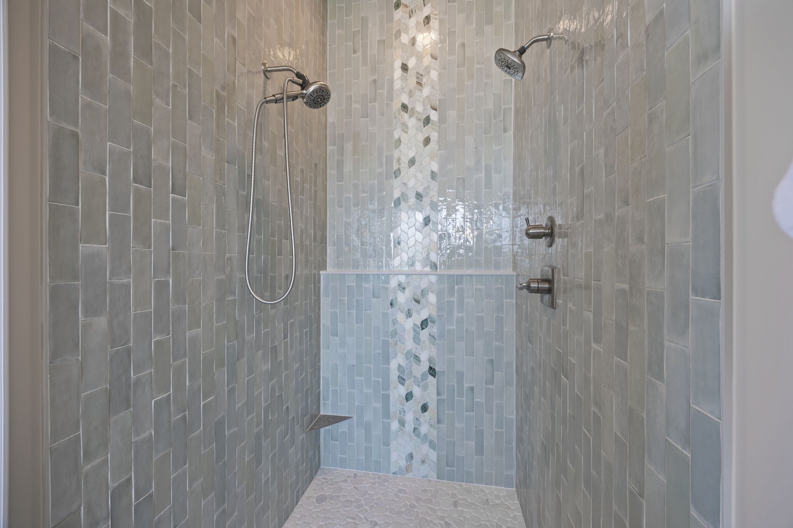 Step into your luxurious dual-head shower with stunning mosaic tilework and rainfall heads for the ultimate spa experience.
