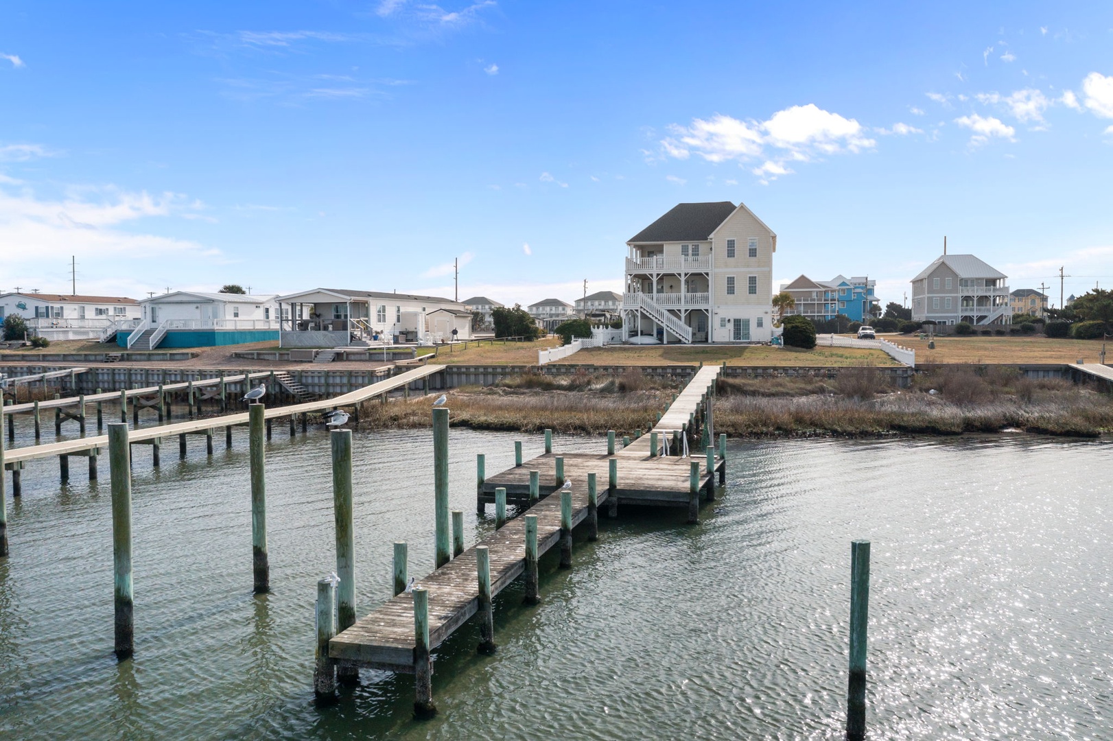 Waterfront community with private docks and boat slips along the canal, featuring coastal homes with elevated designs.