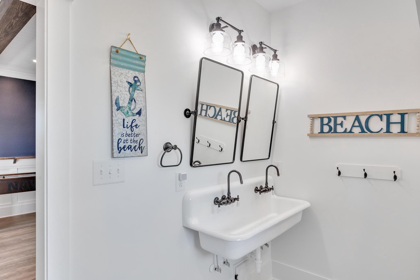 Freshen up in your charming coastal bathroom, where beach-inspired décor and a double trough sink create a relaxed, breezy vibe perfect for your seaside getaway.
