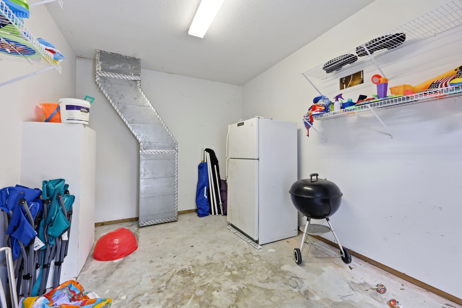 This utility space includes storage, a refrigerator, and BBQ grill—practical amenities to enhance your stay with convenience and outdoor cooking options.