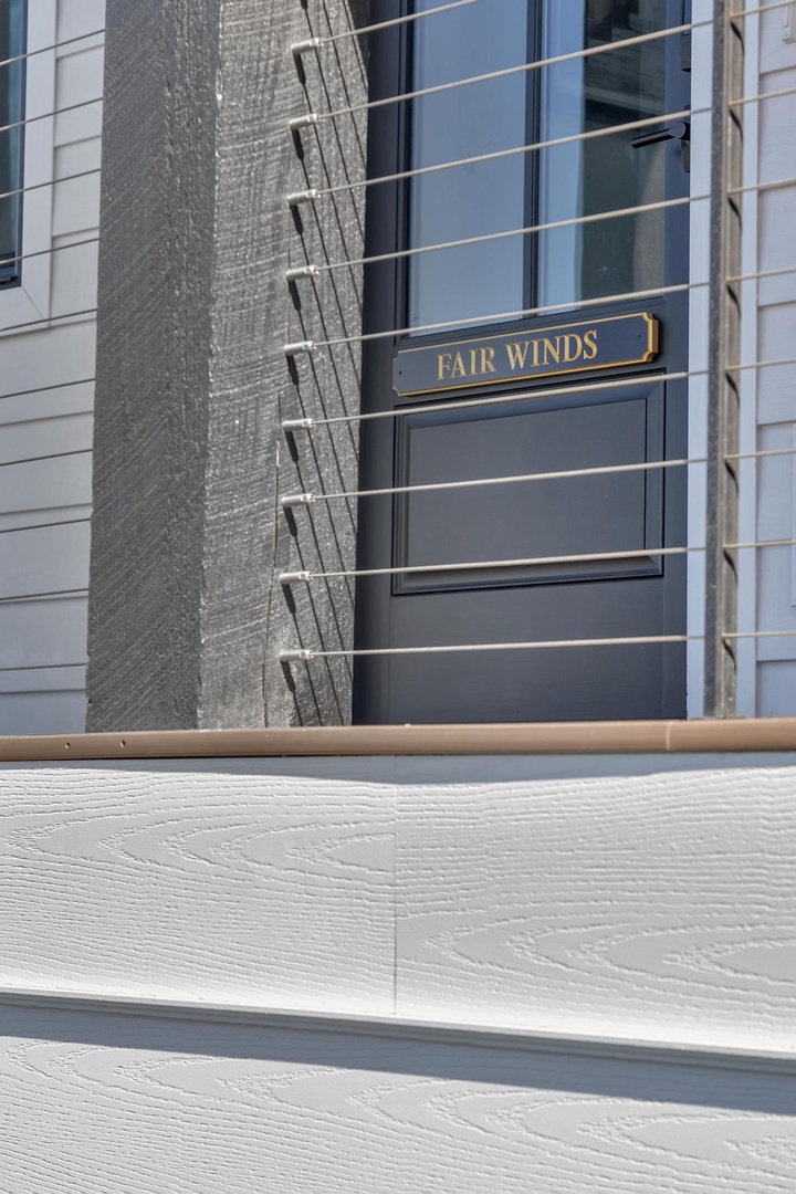 Welcome to Fair Winds. This charming property features a modern façade with clean lines and coastal character, marking your arrival at a relaxing coastal retreat.