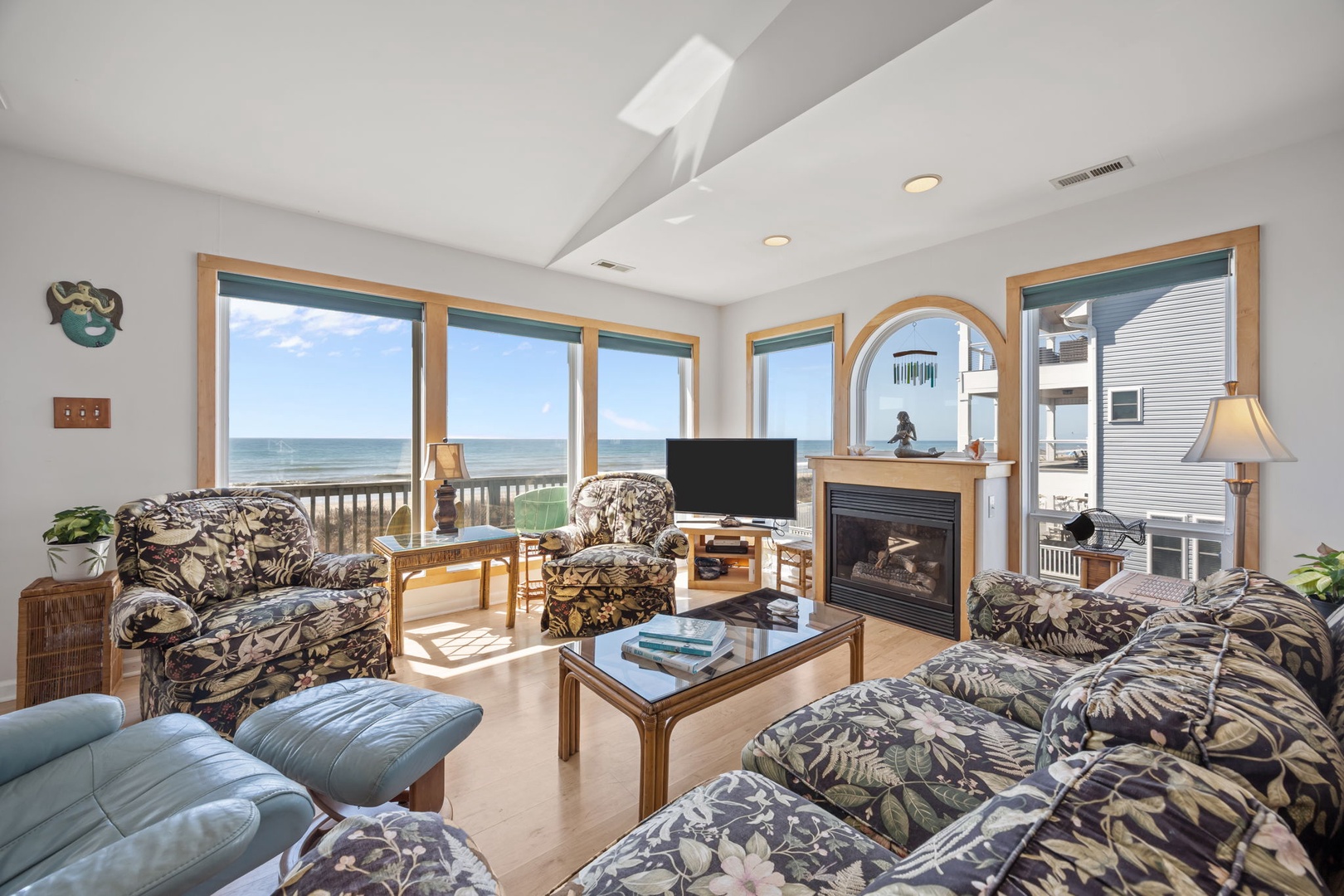 Relax in your oceanfront living room where panoramic sea views stretch endlessly beyond floor-to-ceiling windows, creating the perfect coastal retreat.