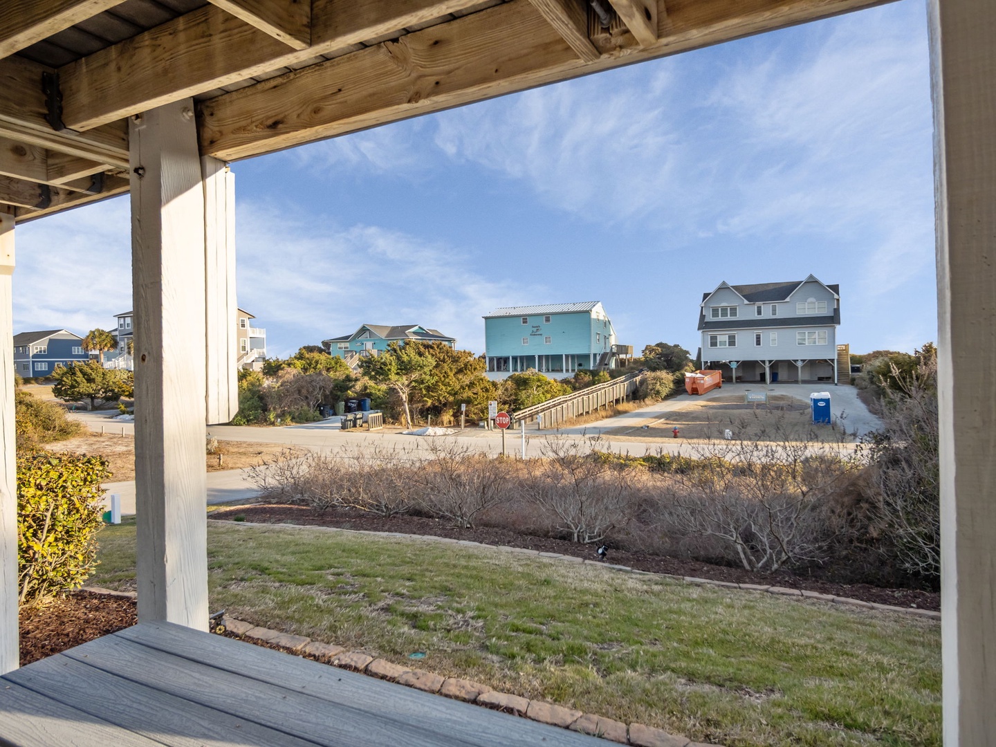 A covered outdoor area provides views of the residential neighborhood and nearby coastal community.