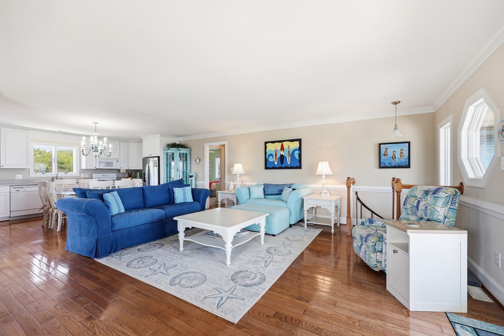 Sink into plush coastal sofas where natural light streams through windows. The open-concept design connects you to the dining and kitchen areas, perfect for gathering with loved ones.