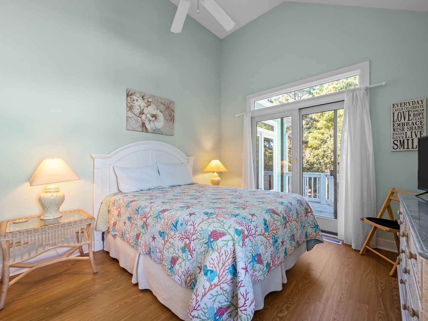 Drift off peacefully in your coastal-themed bedroom featuring coral-patterned bedding, soft lighting, and French doors opening to your private balcony.