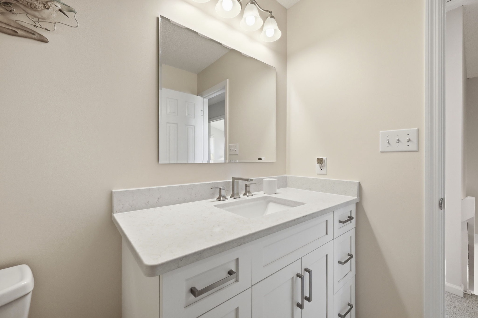 Freshen up at this clean, well-lit vanity with marble countertops and sleek modern fixtures—your perfect spot to start and end your day in comfort.