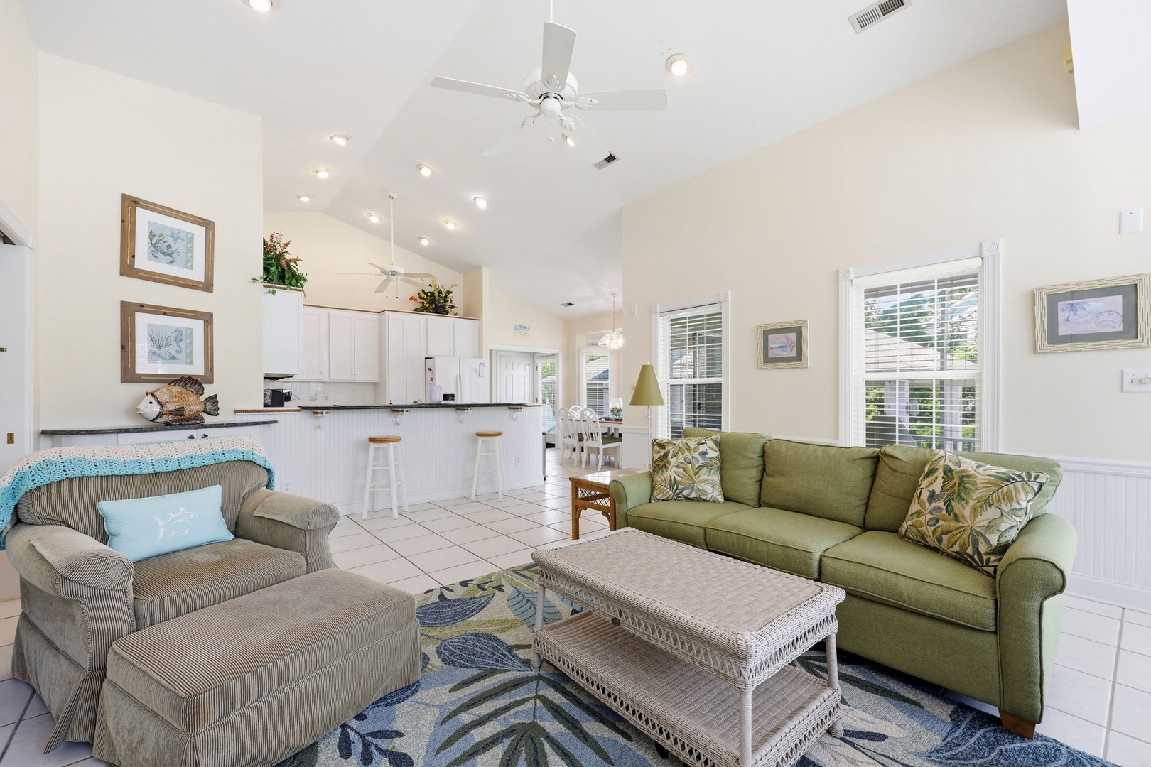 Relax in your open-concept living area with vaulted ceilings, cozy seating, and a fully equipped kitchen. Natural light fills the space, creating a breezy, coastal atmosphere for your stay.