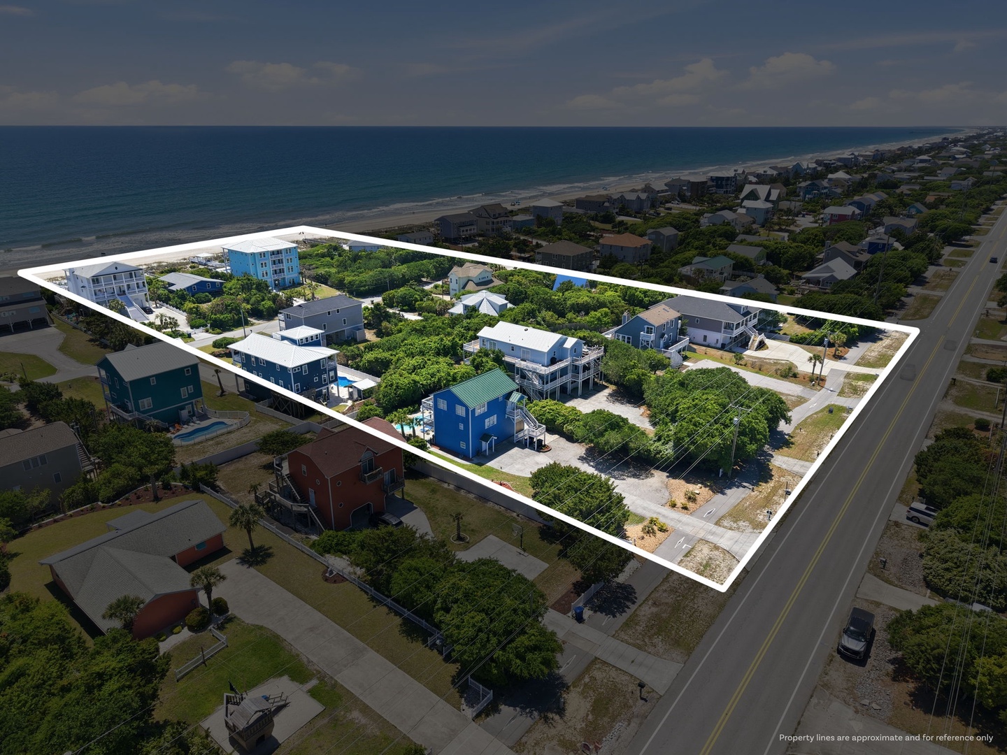 Aerial view of a beachfront property area featuring multiple vacation homes nestled among coastal greenery, with direct beach access and ocean proximity in a residential neighborhood.
