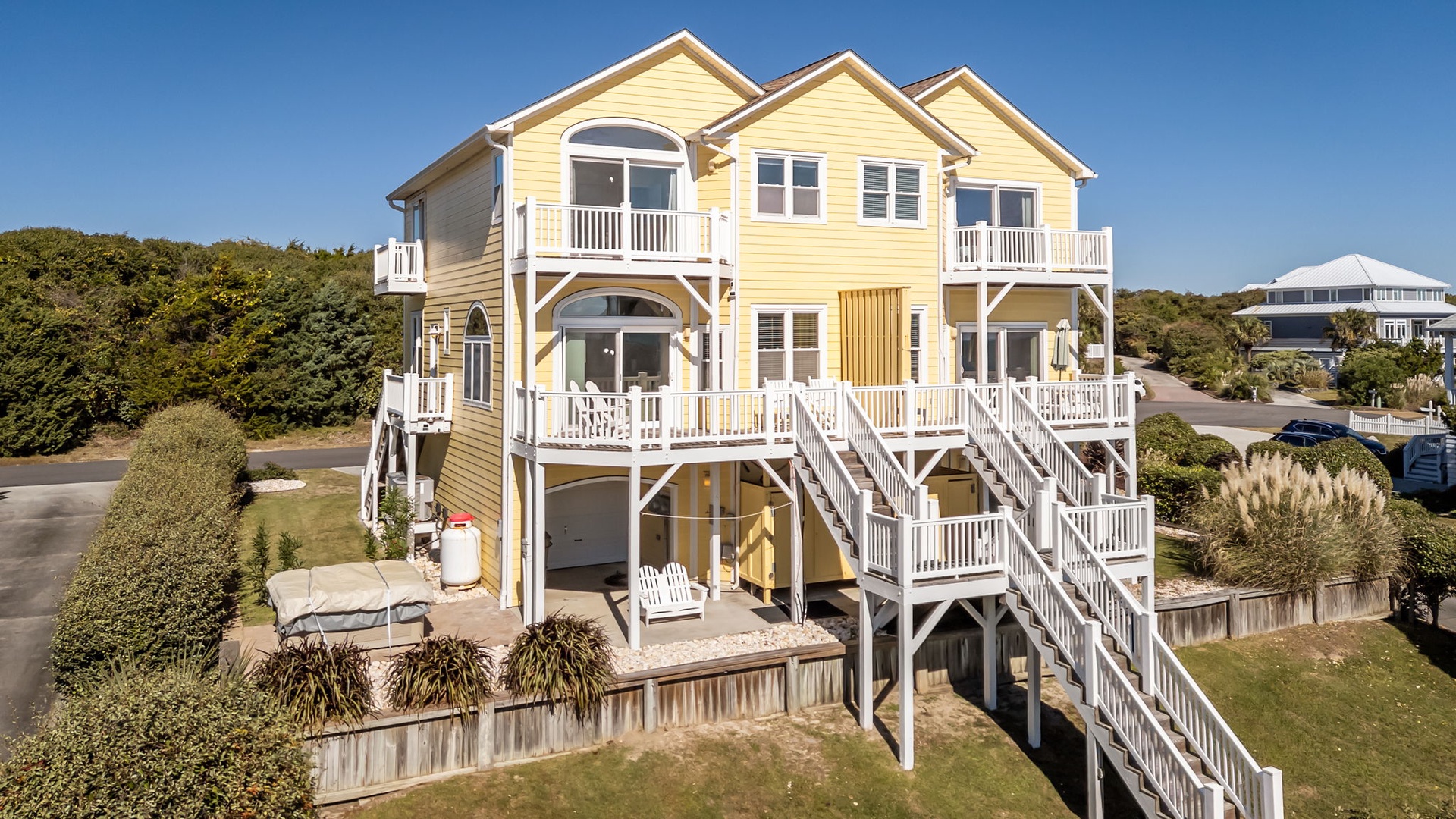 Elevated beach house with multiple balconies and coastal charm in a peaceful neighborhood setting.