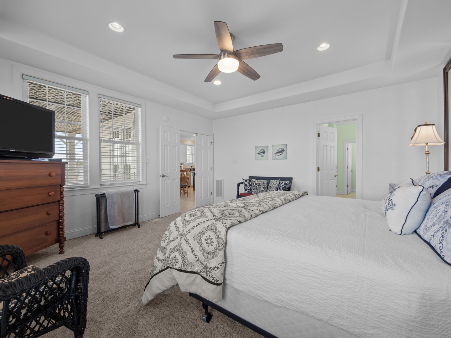 Drift off in your elegant bedroom with crisp linens, ceiling fan comfort, and TV entertainment for the perfect night's rest.