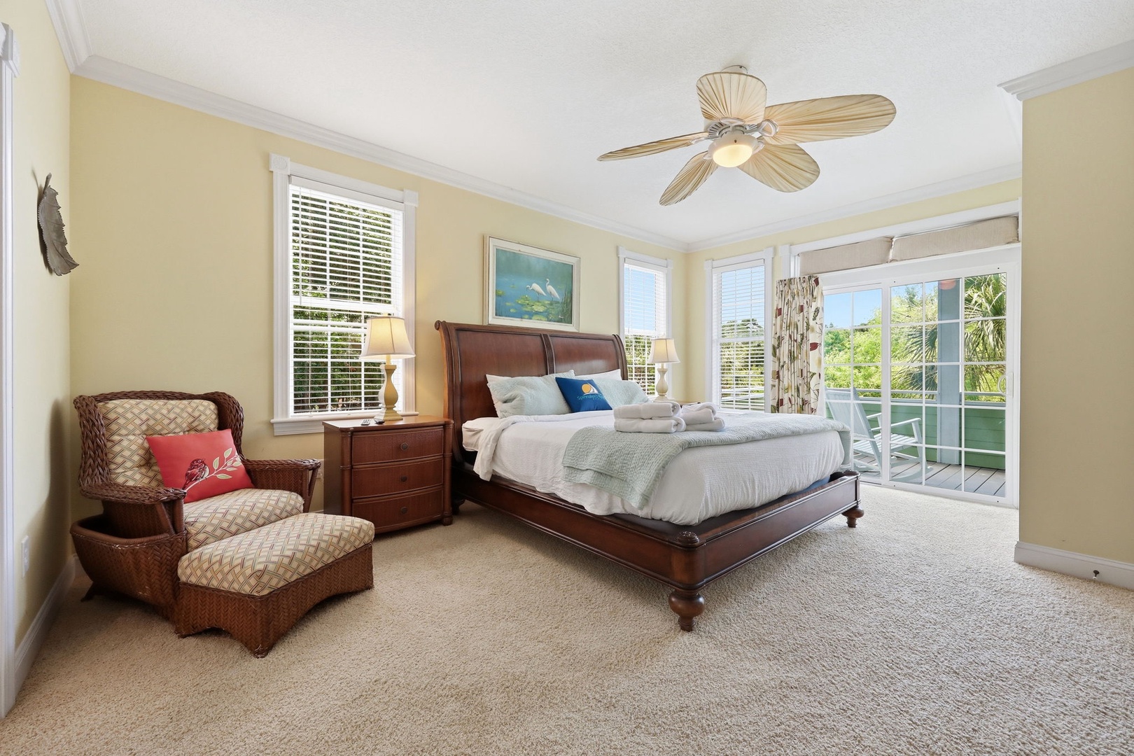 Unwind in your spacious bedroom with coastal charm, a plush king bed, cozy seating, and sliding doors opening to your private balcony with lush tropical views.