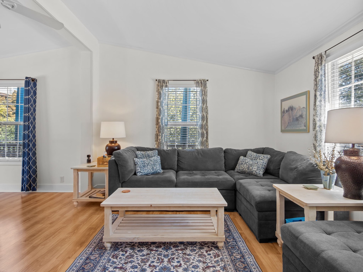 Sink into this plush sectional where natural light streams through patterned curtains, creating your perfect retreat for relaxing after exploring.