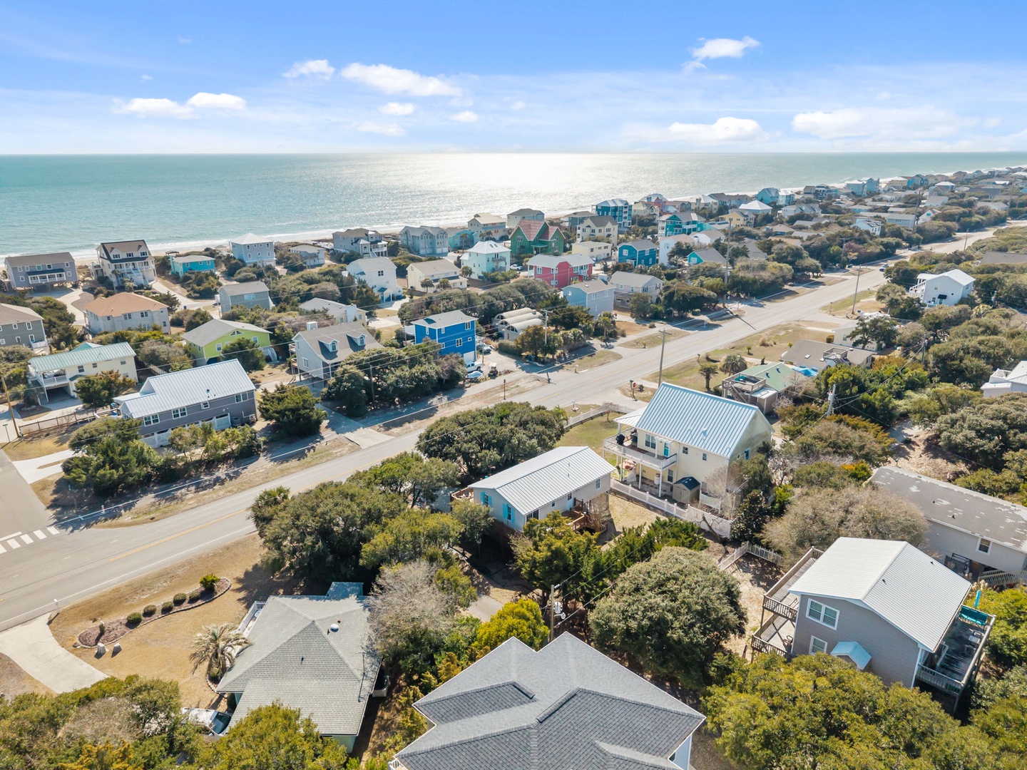 Charming coastal community with colorful beach houses nestled among mature trees, just steps from pristine shores.