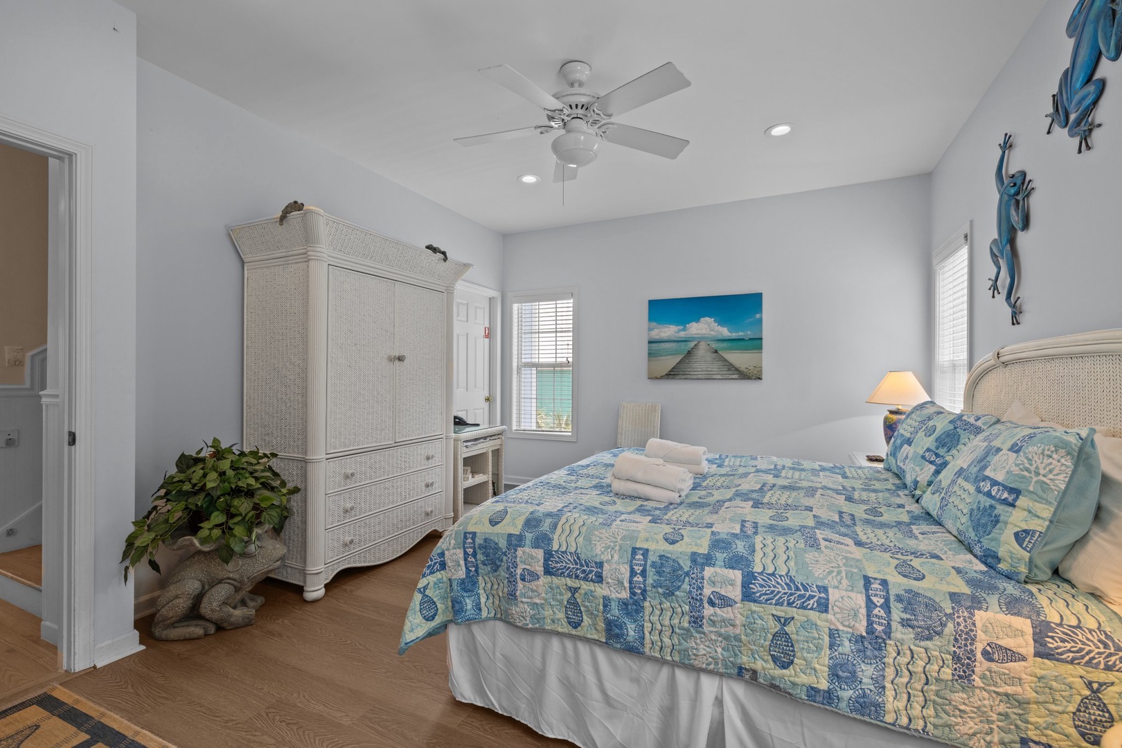 Drift off in this serene coastal bedroom featuring tropical blue linens, warm lighting, and beachy décor that'll make you feel like you're sleeping by the ocean.